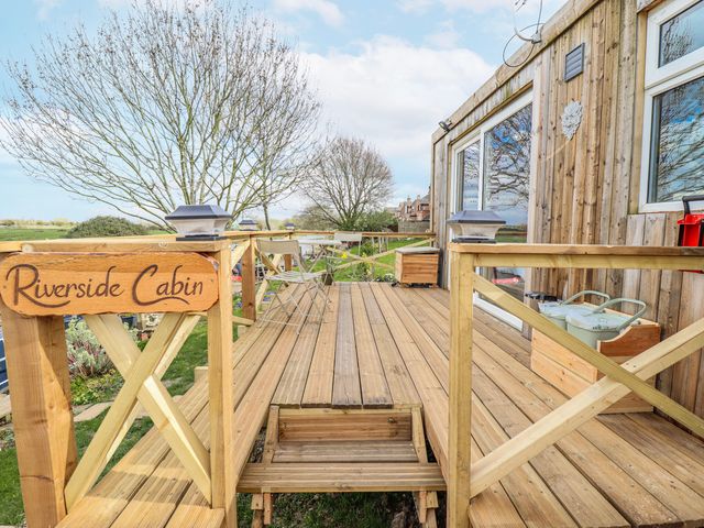 An outdoor deck with a sign at Riverside Cabin in Peterborough