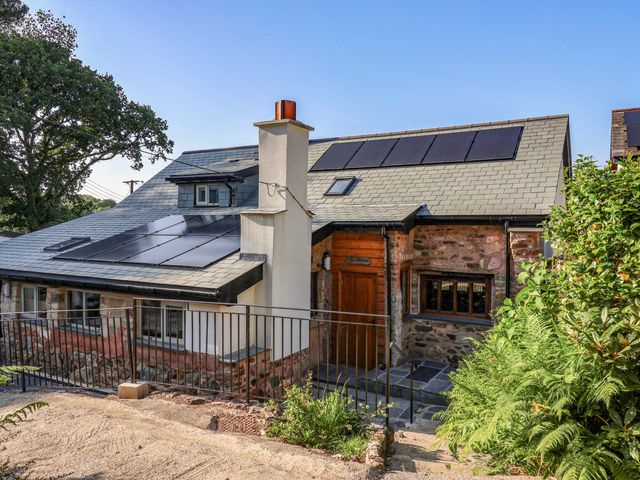 A house with solar panels and a chimney at Heathmoor in Horrabridge