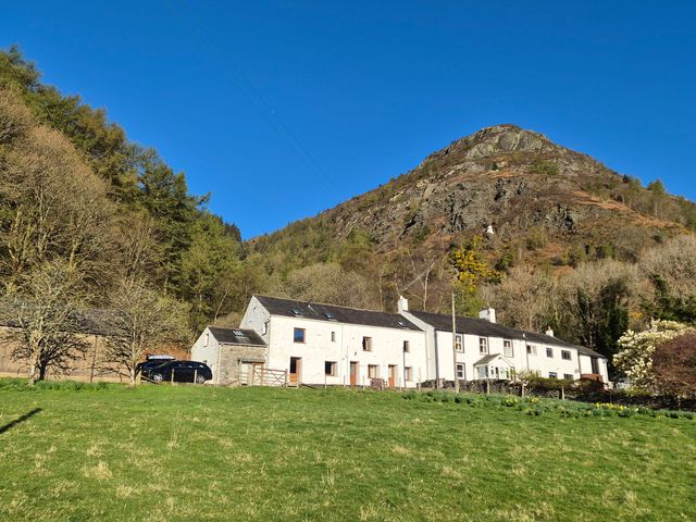 A building with a car in front and a mountain in the background at Bramble Cottage Thornthwaite near Braithwaite