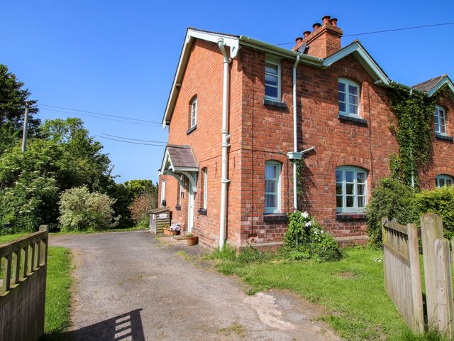 A brick house with a garden and pathway at Shepherd's Cottage in Eudon Burnell near Bridgnorth