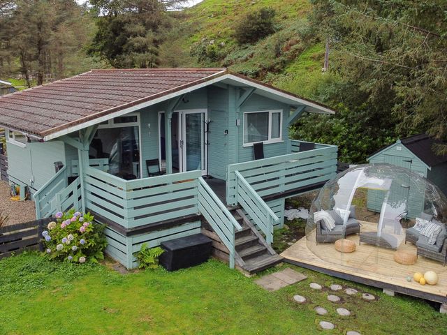 A house with a deck and seating area at Scarba in Balvicar, Isle Of Seil