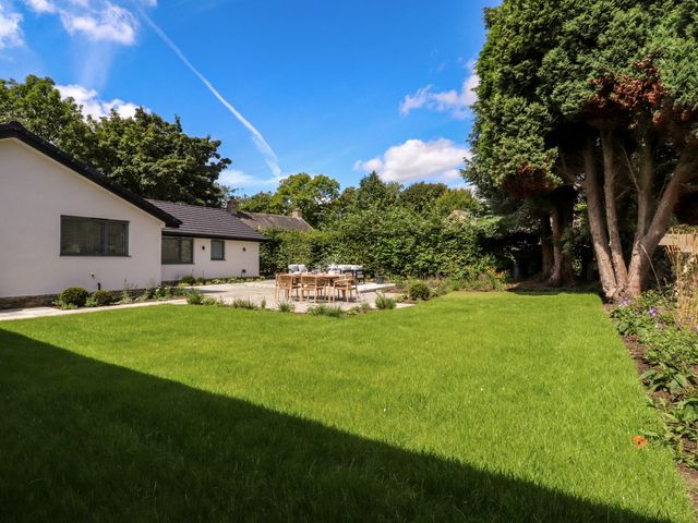 A garden with a dining table and chairs at Cross Winds in Clapham