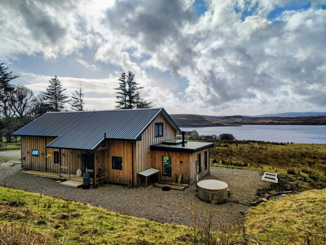 A house near a lake with a hot tub at Faodail House Kingsburgh near Uig
