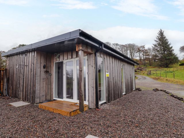 A wooden cabin with glass doors and a gravel pathway at Faodail Studio
