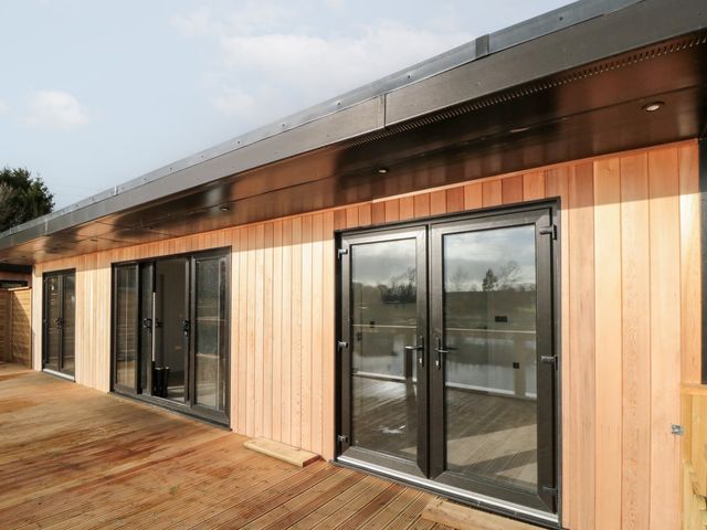 An outdoor view of a wooden building with glass doors at Lodge 6 Stockton-on-Tees