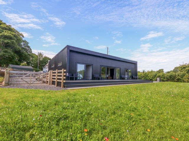 An outdoor view of a house with patio and fence at Y Cwt Moelfre