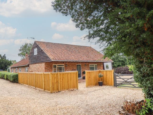A house with a fence and garden at Wood Farm Cottage in Stickney near East Kirkby
