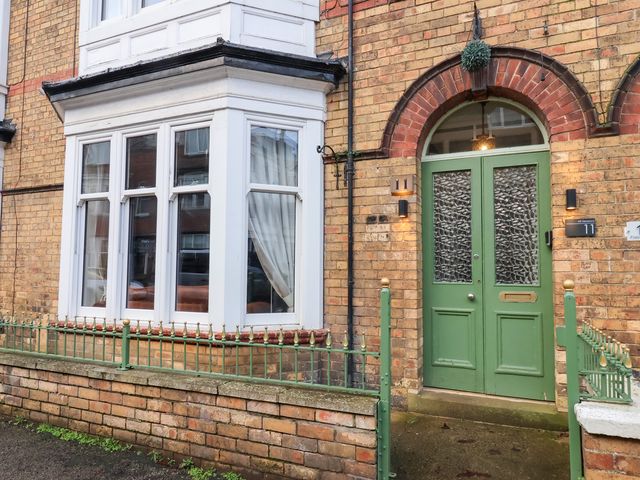 An entrance with a green front door and bay window at All Seasons in Filey