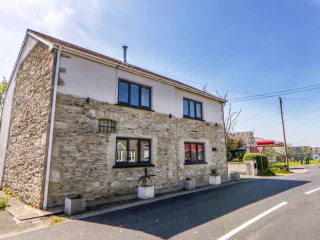 A house with stone exterior and windows on the street at La Bastille in Maenclochog