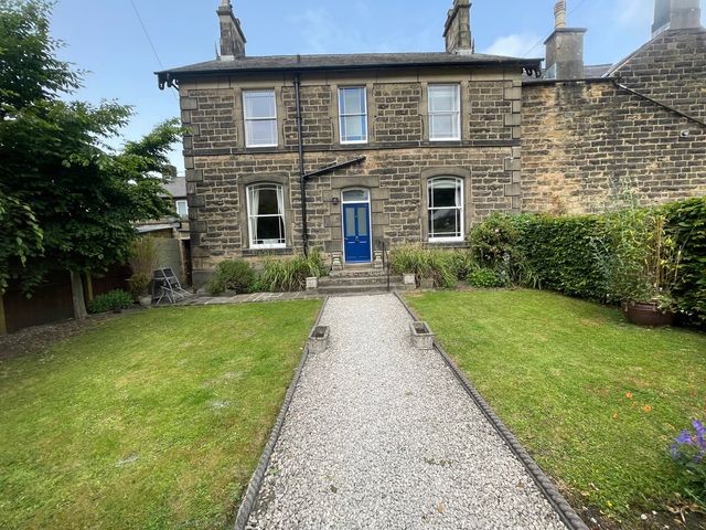 A house with a blue front door and a garden at Deeley House in Darley Dale