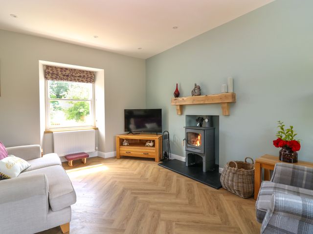 A living room with a television and fireplace at Ashlea in Oxton near Lauder