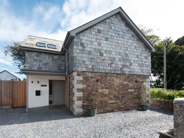 A house with stone wall and shingle roof at Pentire in St Minver