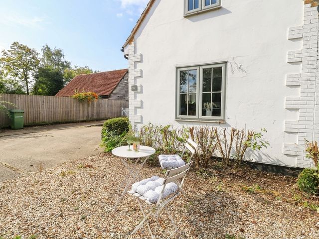 A patio with a table and chairs at Horseshoe Stable in Mattishall