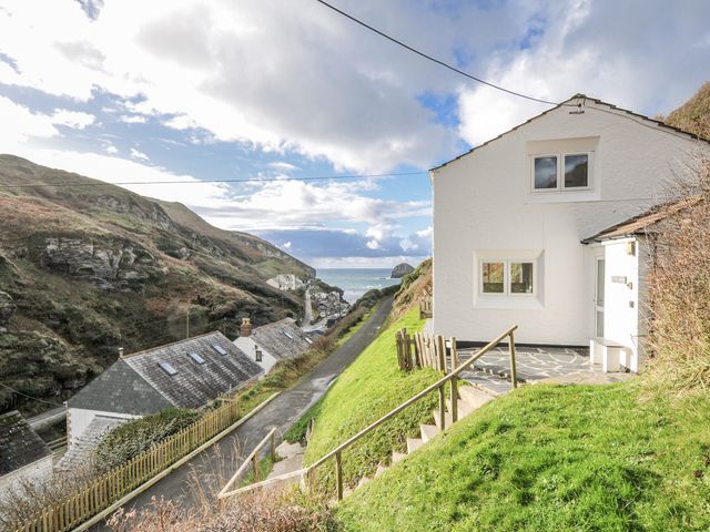 A house on a hillside overlooking the sea at Little Ruffo, Trebarwith near Tintagel