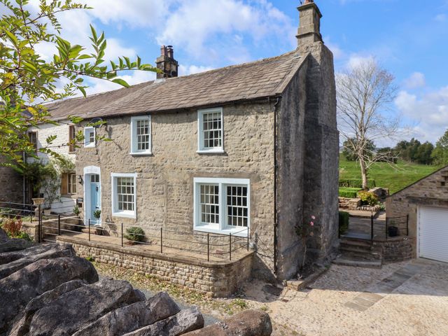 A stone house with windows and a door at Ellis House in Skipton