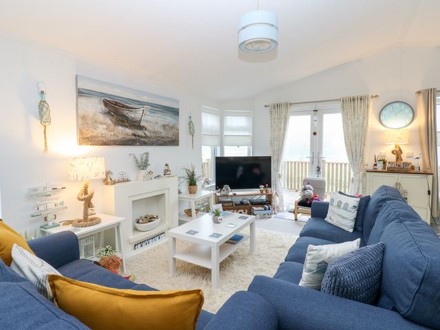 A living room with a coffee table and a television at The Sanctuary Badgers Retreat Holiday Park near Catterick Garrison, North Yorkshire