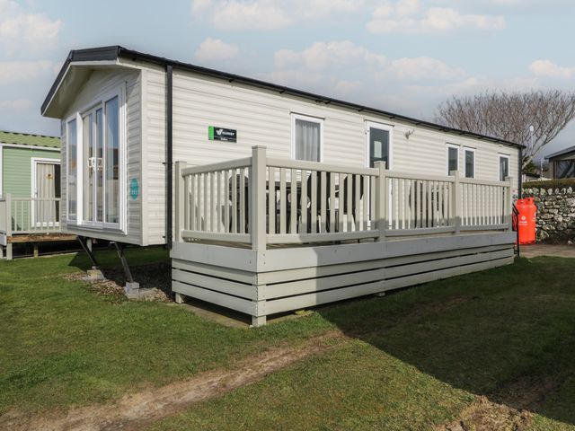 A caravan with a deck and outdoor seating at Gold Caravan (203) Talybont