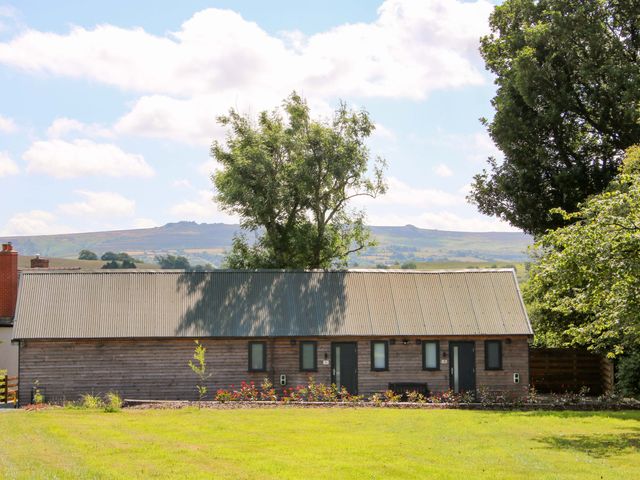 A building with a metal roof and trees at Stiper View Barn 1 Gravels Bank