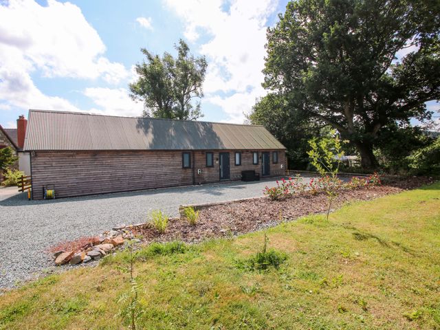 An outdoor view of a wooden house with garden at Stiper View Barn 2 Gravels Bank
