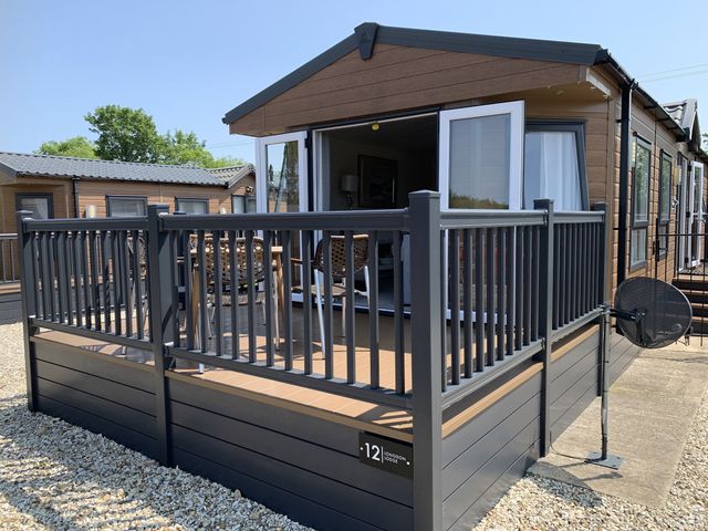A deck with railing and outdoor furniture at Longdon Lodge in Wickhamford near Evesham