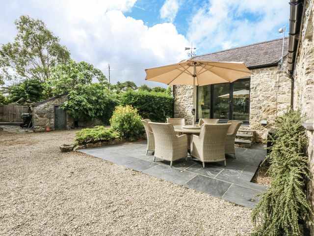 An outdoor patio with table and chairs at Tyddyn Iolyn in Benllech