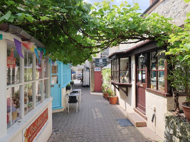 An alley with storefronts and outdoor seating at Drake's Hideaway in Lyme Regis