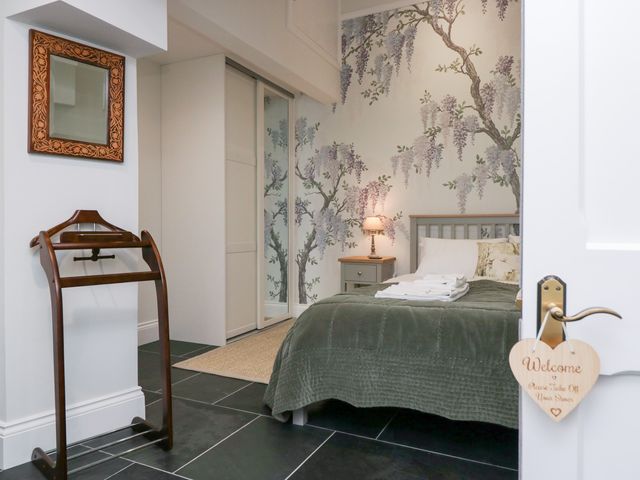 A bedroom with a bed and bedside table at Pippins in Ambleside