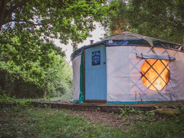 A yurt with a lit interior in a wooded area at Brandon House Farm Yurt Brandon Parva near Mattishall