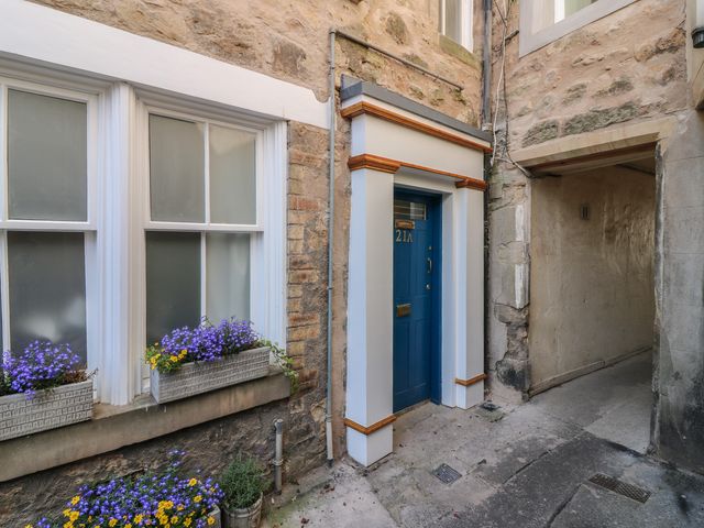 An entrance with a blue door and flower boxes at 21A High Street in Jedburgh