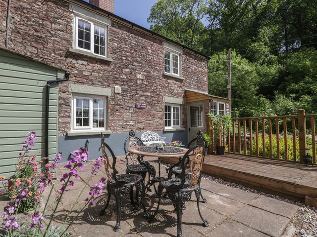 A patio with a table and chairs at Court House Cottage in Gatcombe near Blakeney