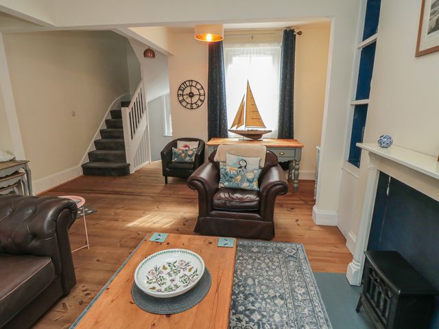 A living room with a sofa, coffee table, and a staircase at 1 Albion Place, Whitby