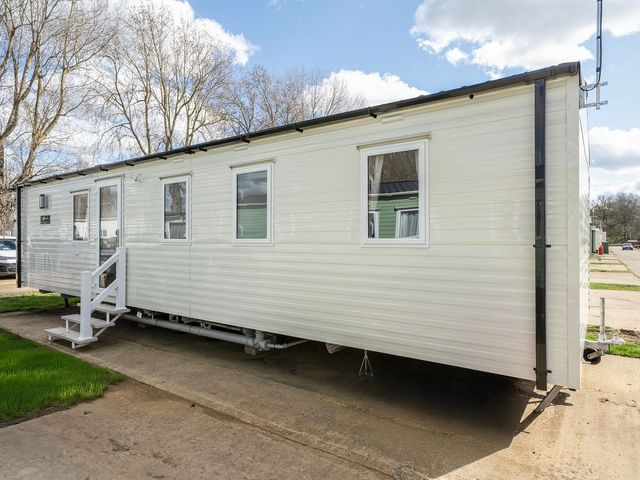 A caravan parked on a concrete path at Sand and Splash - Hayling Island