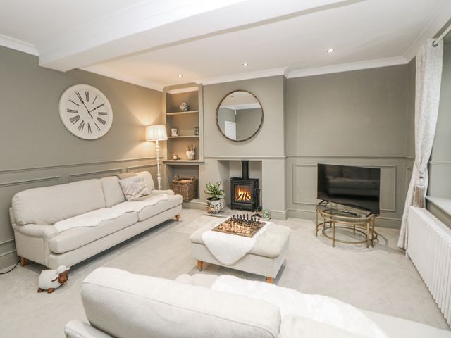 A living room with a fireplace and sofa at Hallfield Hall Cottage in Shirland