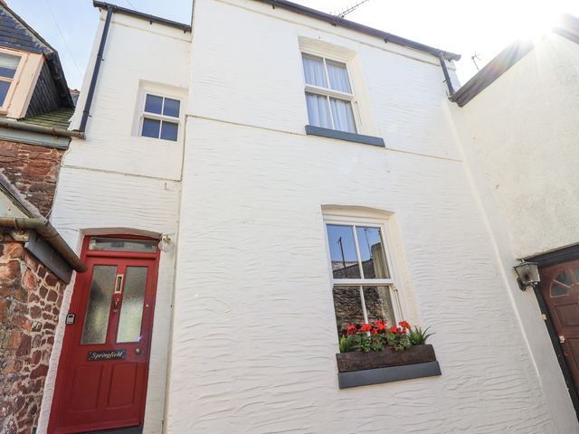An exterior view of a white house with a red door and flower box at Springfield in Kingsand