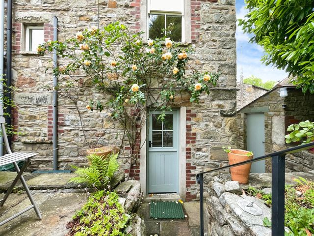 An outdoor area featuring a stone wall and flowers at 3 Chapel Square Brookhouse near Caton