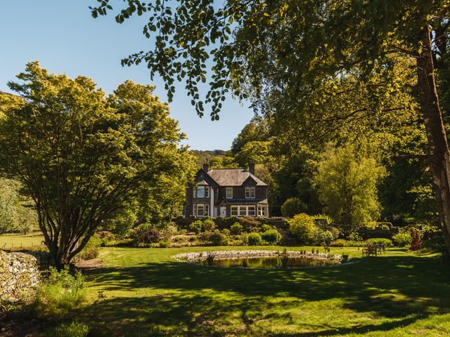 A house surrounded by trees and a pond in the garden at Leathes Head Country House Borrowdale near Keswick