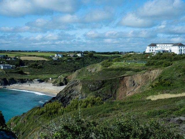 A coastal landscape with cliffs a sandy beach several houses and a large white building on a hill at Villa 2 in Mullion