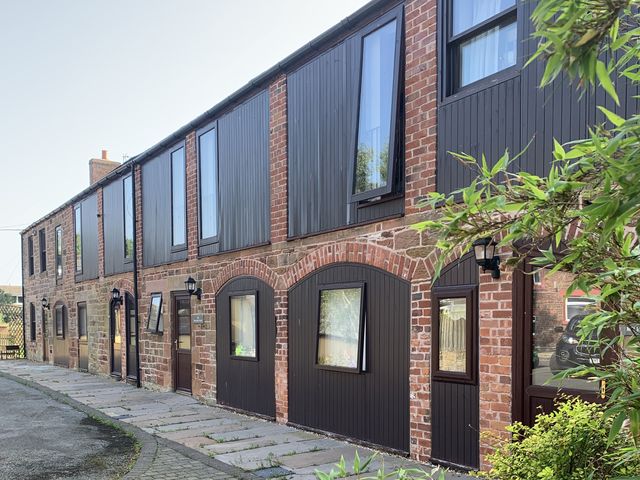 An outdoor view of a brick building with multiple windows at The Coach House near Wigton