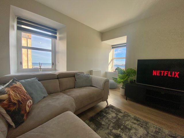 A living room with a sofa and television at 3 The Granary in Banff