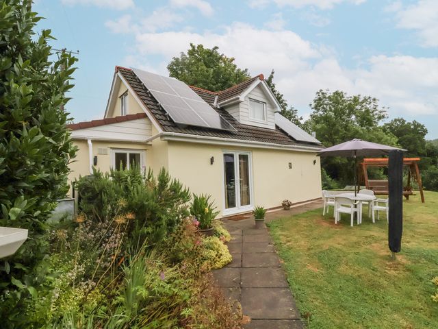 A house with solar panels and garden furniture at Hideaway in Great Torrington