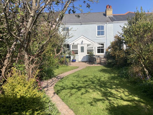 A garden with a house and seating area at 5 Bed Cottage Mumbles in Mumbles