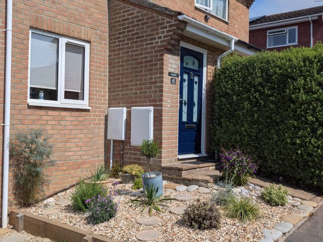 A front entrance with plants and a blue door at Seahills Lyme Regis