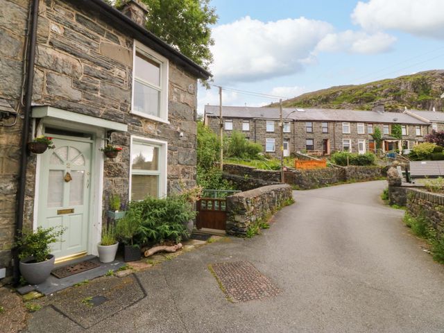A stone house with a front door and plants at Waterfall Retreat in Blaenau Ffestiniog