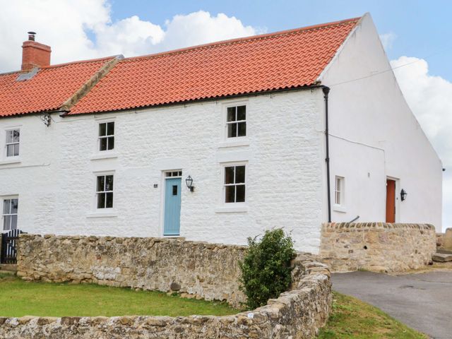 A house with a blue door and stone wall at Peace Cottage Langton near Gainford