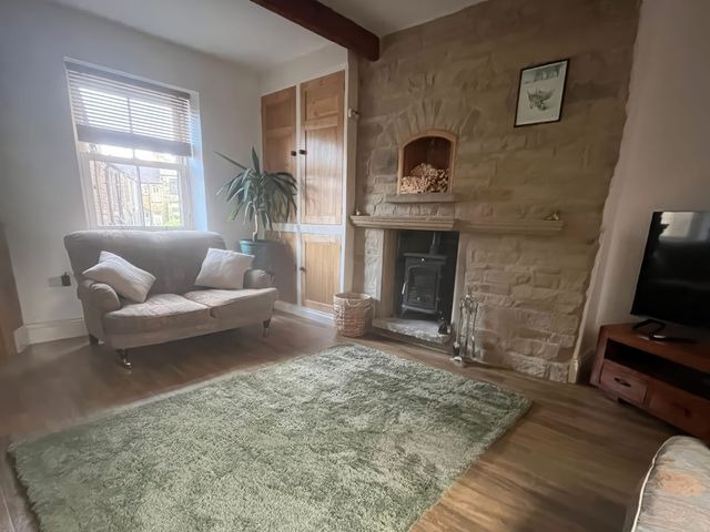 A living room with a sofa and fireplace at 12 Queen Street in Keighley