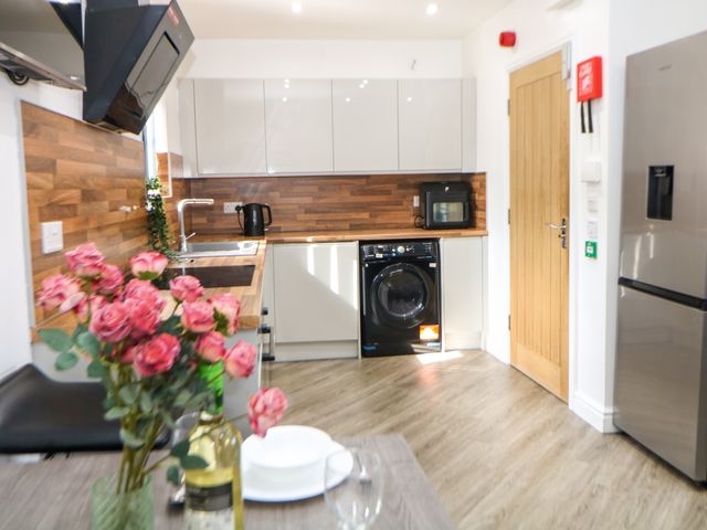 A kitchen with appliances and wooden cabinets at Don Valley Apartment A