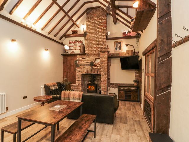 A living room with a fireplace and television at Dotty's Den in Bridlington