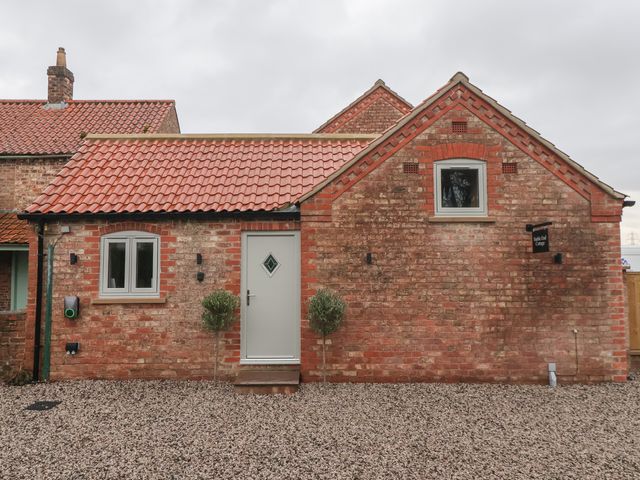 A front view of a cottage with a gravel area at Stable End Cottage in York