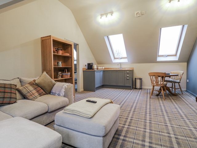 A living room with a sofa and kitchenette at The Walnut Room - Windmill Country Retreats Wymondham near Buckminster