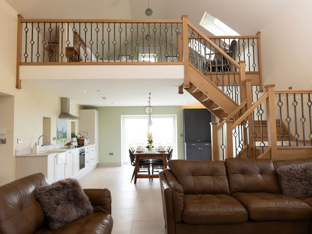 A living room with a staircase and dining area at Golygfa Cwrt, Talybont